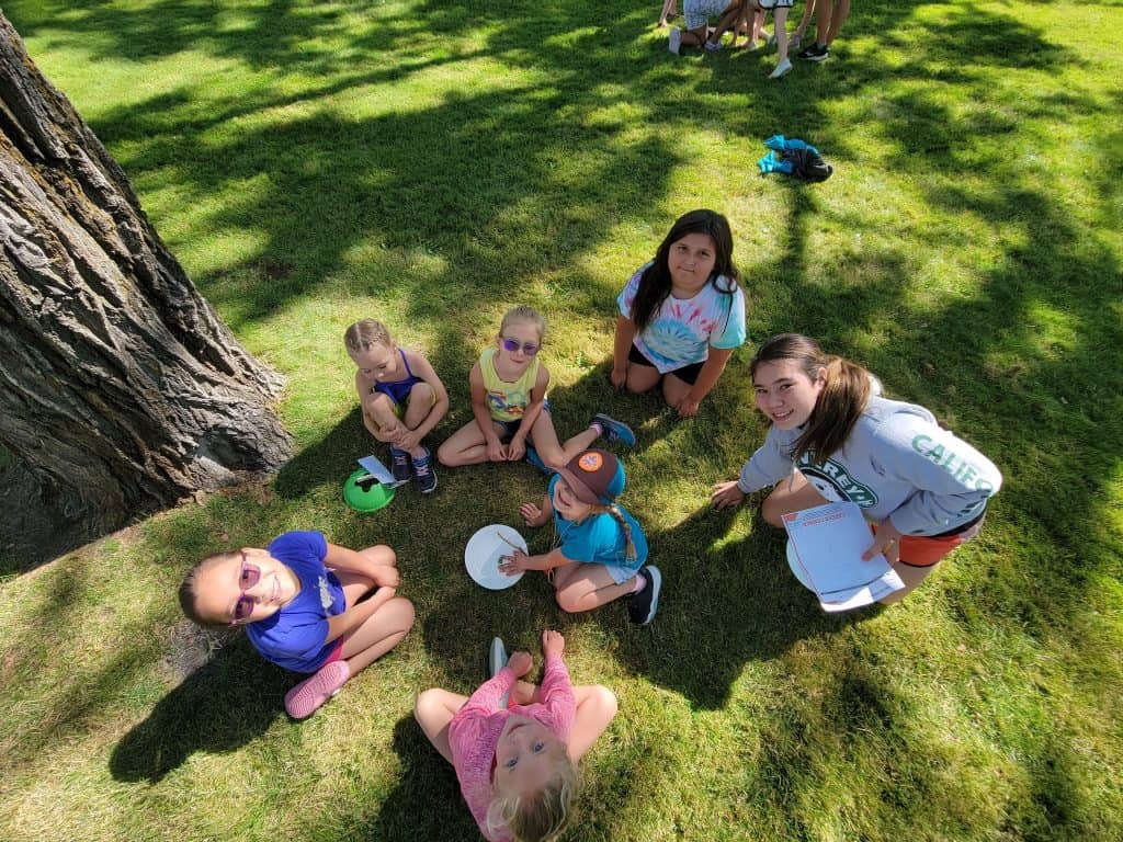 Group of young people sitting under a tree participating in "career corner"